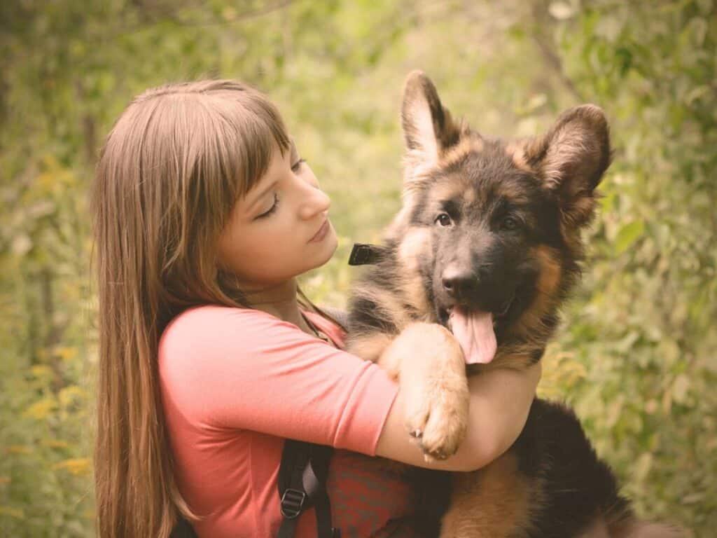 woman holding a german shepherd puppy